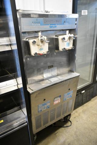 Taylor 755-27 Stainless Steel Commercial Floor Style 2 Flavor Soft Serve Ice Cream Machine on Commercial Casters. 208/240 Volts, 1 Phase.