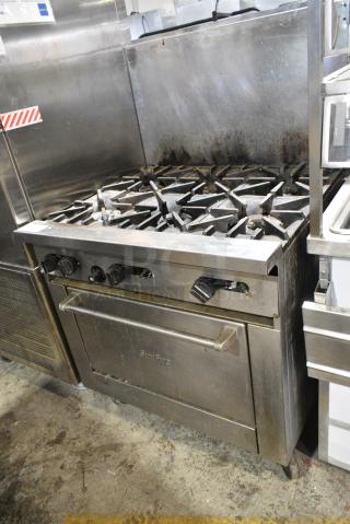 Garland SunFire Stainless Steel Commercial Natural Gas Powered 6 Burner Range w/ Oven and Back Splash on Commercial Casters.