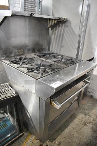 Garland Stainless Steel Commercial Natural Gas Powered 4 Burner Range w/ Oven, Over Shelf and Back Splash on Commercial Casters.