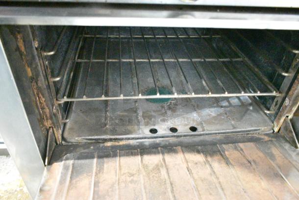 Garland Stainless Steel Commercial Natural Gas Powered 4 Burner Range w/ Oven, Over Shelf and Back Splash on Commercial Casters. - Image 4 of 7