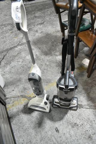2 Various Shark Vacuum Cleaners. 2 Times Your Bid! Gray is Tested and Working but White Vacuum Needs Battery Charge