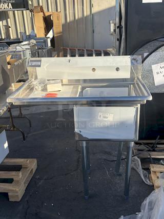 BRAND NEW SCRATCH & DENT! Steelton 522CS11818LT  38 3/4" 18-Gauge Stainless Steel One Compartment Commercial Sink with Left Drainboard - 18" x 18" x 12" Bowl. Includes drains, screws and legs. Legs are slightly bent (see photos).