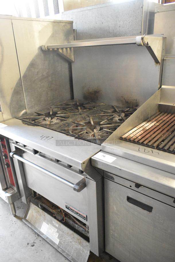Garland M44R Stainless Steel Commercial Natural Gas Powered 4 Burner Range w/ Oven, Back Splash and Over Shelf. 40,000 BTU. - Image 1 of 6