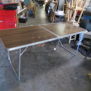 One Folding Table With A Laminate Top And A Carry Handle. 72X30X30