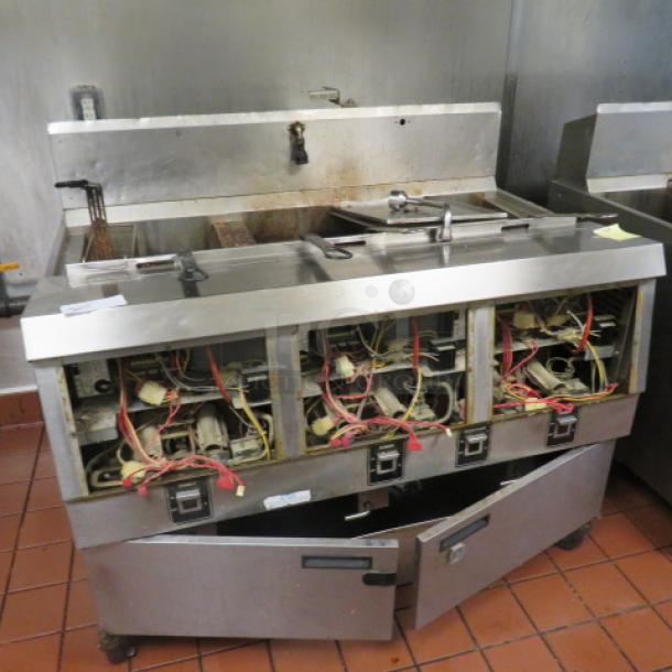 One Henny Penny  Natural Gas 3 Vat Open Fryer On Casters With 5 Baskets. Model# OFG-323.  120 Volt. Missing Front Panels. 49.5X33.5X44. $25,367.00 - Image 1 of 1