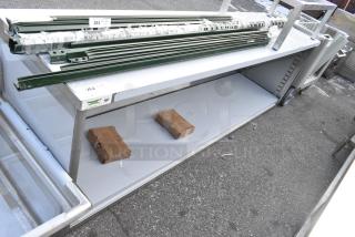 BRAND NEW SCRATCH AND DENT! Regency 600EBT2496 24" x 96" 16 Gauge Type 304 Stainless Steel Enclosed Base Table with Open Front and Adjustable Midshelf