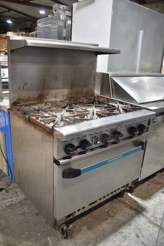 Radiance Stainless Steel Commercial Natural Gas Powered 6 Burner Range w/ Oven, Over Shelf and Back Splash on Commercial Casters.