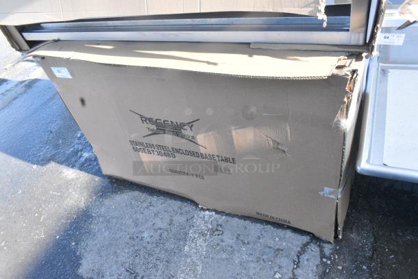 BRAND NEW SCRATCH AND DENT! Regency 600EBT3048D 30" x 48" 16 Gauge Type 304 Stainless Steel Enclosed Base Table with Sliding Doors and Adjustable Midshelf - Image 1 of 2