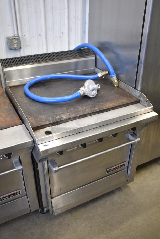 Garland M47R Stainless Steel Commercial Natural Gas Powered Flat Top Griddle w/ Oven and Back Splash. - Image 1 of 7