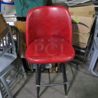 One Red Cushioned Bar Height Chair With Footrest And A Swivel Seat.
