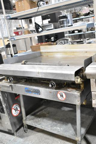 Imperial Stainless Steel Commercial Natural Gas Powered Flat Top Griddle w/ Metal Under Shelf.