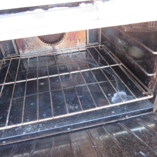 One Garland 10 Burner Natural Gas Range With Stainless Steel Over Shelf, And 2 Racks On Casters. Model# G60-10CC. 60X39X57.   $13,567.00 - Image 3 of 3