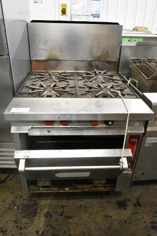 Vulcan Stainless Steel Commercial Natural Gas Powered 4 Burner Range w/ Oven and Back Splash on Commercial Casters.