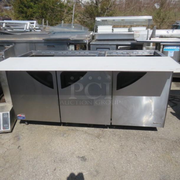 One Turbo Air 3 Door Refrigerated Prep Table With Cutting Board And 3 Racks, On Casters. Missing 2 Lids. Model# TST-72SD-30-N. 115 Volt. 73X34X45 - Image 1 of 3