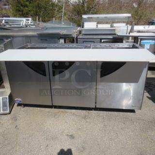 One Turbo Air 3 Door Refrigerated Prep Table With Cutting Board And 3 Racks, On Casters. Missing 2 Lids. Model# TST-72SD-30-N. 115 Volt. 73X34X45