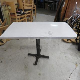 One White Laminate Table Top With A Chrome Rim On A Pedestal Base. 48X27X30