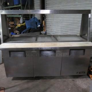 One WORKING True 3 Door Refrigerated Prep Table With 3 Racks, Cutting Board, And SS Over Shelf With A Lift Top, On Casters. Model# TSSU-72-30M-B-ST. 115 Volt. 72X35X60.5. $5764.77.