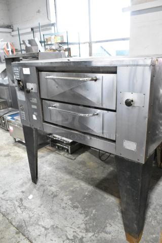 Bakers Pride GS805 Stainless Steel Commercial Natural Gas Powered Single Deck Pizza Oven w/ Cooking Stones on Metal Legs.