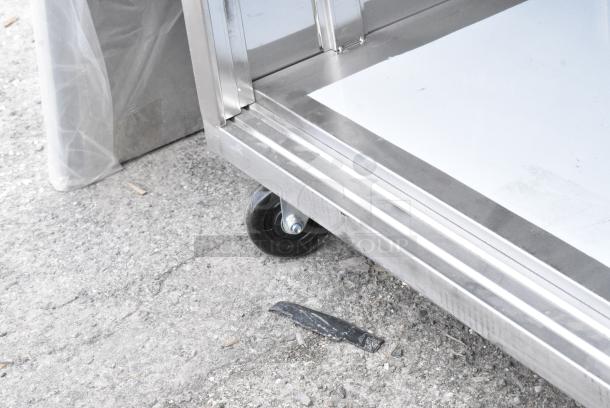 BRAND NEW SCRATCH AND DENT! Regency 600EBT3060R 30" x 60" 16 Gauge Type 304 Stainless Steel Enclosed Base Sliding Door Table with Drawers on Commercial Casters - Image 3 of 5