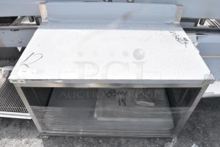 BRAND NEW SCRATCH AND DENT! Regency 600EBTB3048D 30" x 48" 16 Gauge Type 304 Stainless Steel Enclosed Base Sliding Door Table with Adjustable Midshelf and 6" Backsplash