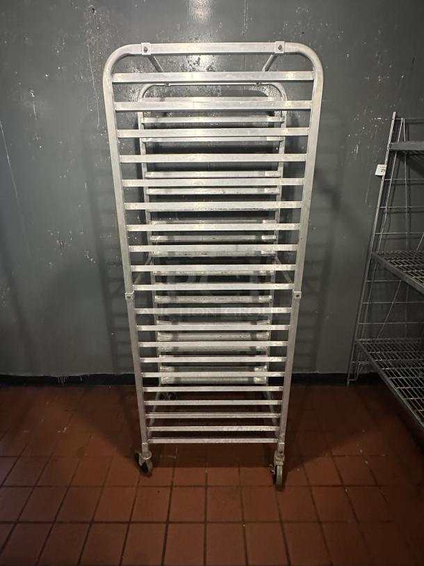 ALMOST PERFECT! Intermediate Height 18 Level 64" End Load Rack. Condition: 8/10 A hard working, versatile line of racks Construction: High tensile extruded aluminum Dimensions: 64"H x 21 3/8"W x 26 1/2"D Tray supports: 1-1/2″ wide extruded pan supports riveted to uprights Center Spacing: 3" Pan Capacity: (18) 18" x 26" pans Casters: 5" non-marking swivel threaded stem Actual Weight: 45 lbs. - Image 2 of 2