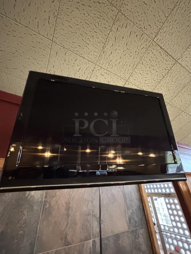 Seiki TV, on swivel base mounted to wall, 20X30 with remote - Image 1 of 5