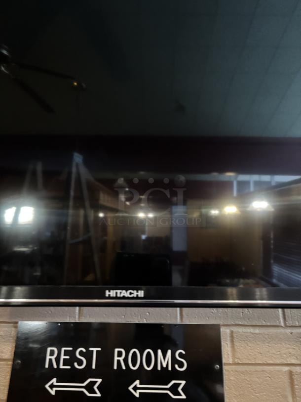 Hitachi Roku TV, swivel mounted to wall, you are responsible for detaching, powered on working 25x43in, with remote - Image 2 of 3
