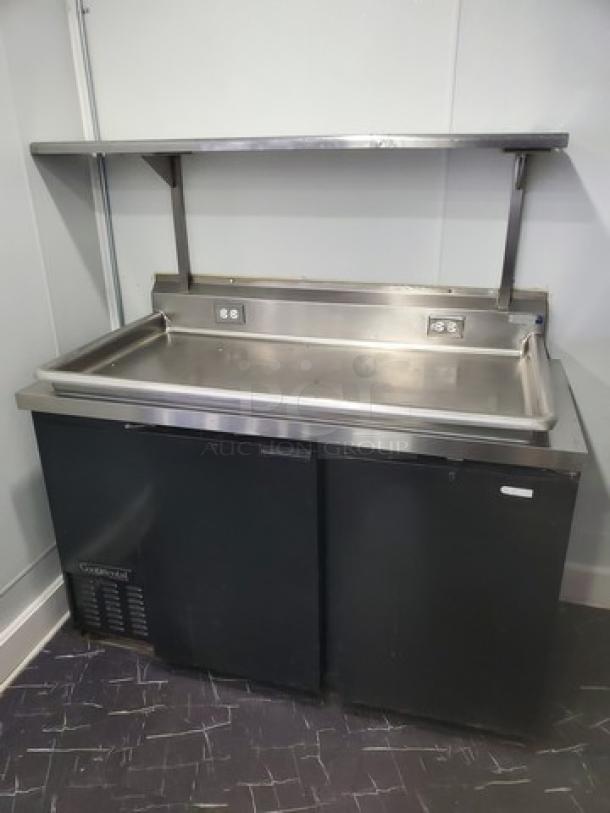 Continental Keg Cooler/ Custom Workstation. No Taps included. Taps were removed (essentially turning it into an under counter cooler) and a stainless steel table top was attached to the top of the cooler. The cold air generated from the cooler travels up through the holes where the taps used to be and keeps the table top nice and cool as well. Overhead shelf is also attached. Very cool custom work station. - Image 1 of 8