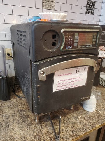 Rapid-cook oven with visible chassis damage and dents