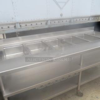 One Stainless Steel Delfield 6 Well Steam Table With A SS Under Shelf, Back Splash, On casters. 208-230 Volt 1 Phase. Unable To Test. 102X35X40
