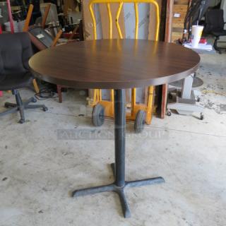 One Brown Laminate Round Table Top On A Bar Height Pedestal Base. 36X42