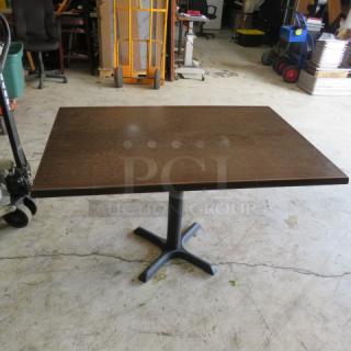 One Brown Laminate Table Top On A Pedestal Base. 48X30X30