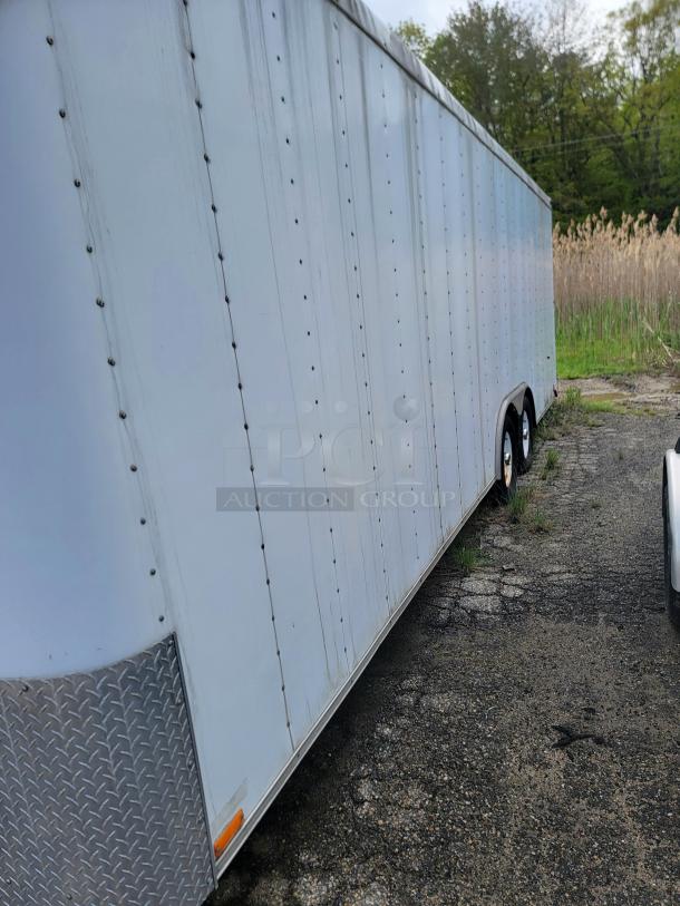 24' Continental Cargo Enclosed Tandem Axle Trailer! Comes with spare tire.*CONTENTS NOT INCLUDED* Equipped with overhead lighting, wood paneling interior, shelving, and electrical outlets! - This item is off site in Biddeford. - Image 3 of 15