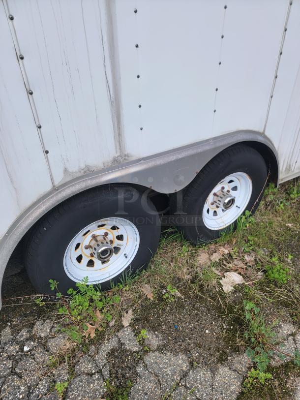 24' Continental Cargo Enclosed Tandem Axle Trailer! Comes with spare tire.*CONTENTS NOT INCLUDED* Equipped with overhead lighting, wood paneling interior, shelving, and electrical outlets! - This item is off site in Biddeford. - Image 6 of 15