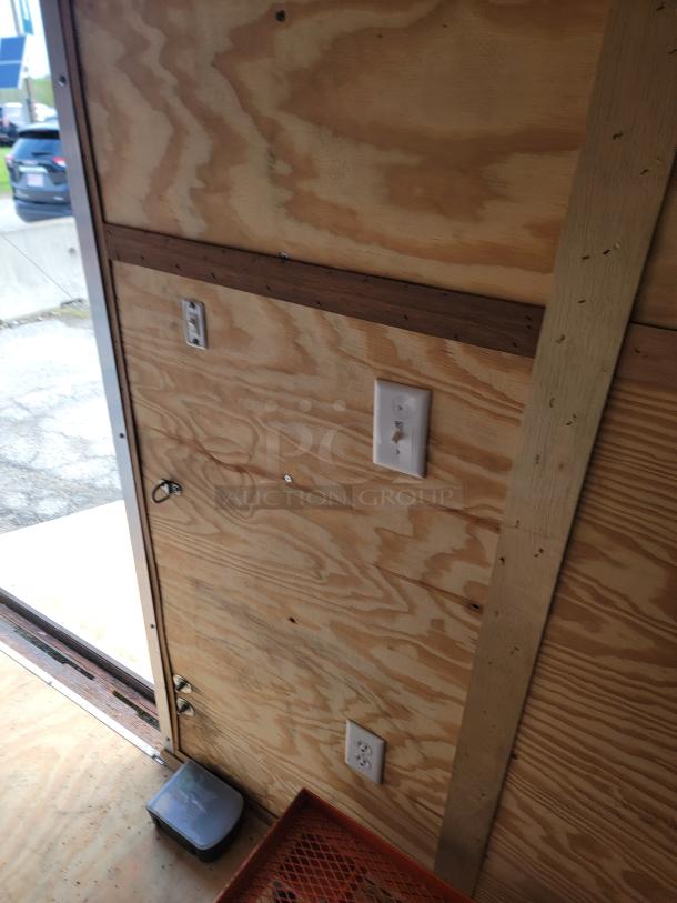 24' Continental Cargo Enclosed Tandem Axle Trailer! Comes with spare tire.*CONTENTS NOT INCLUDED* Equipped with overhead lighting, wood paneling interior, shelving, and electrical outlets! - This item is off site in Biddeford. - Image 11 of 15