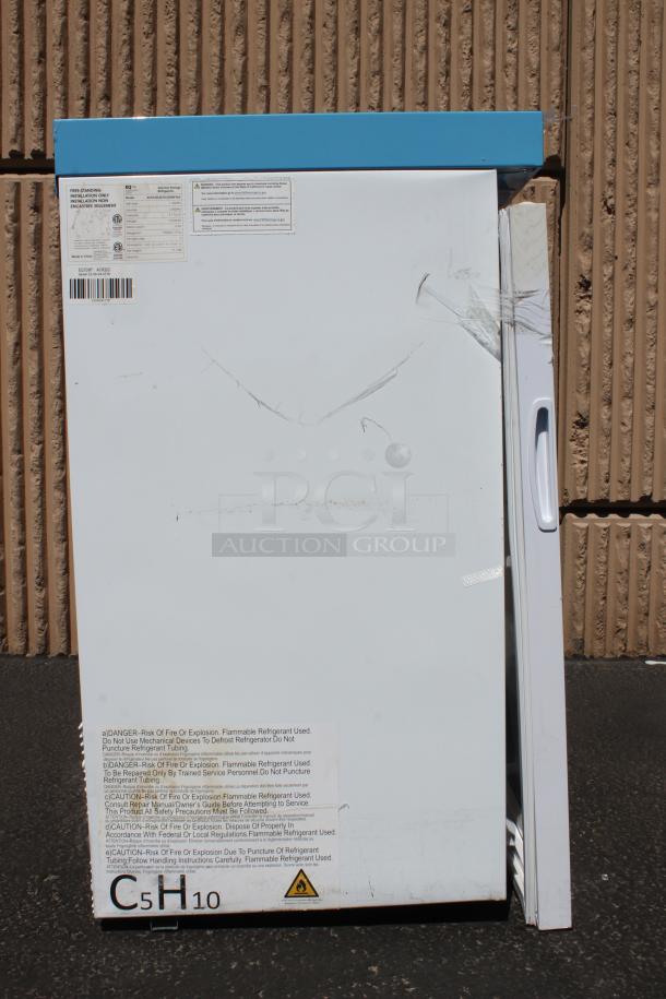White freezer with blue top, visible scratches, and safety labels. Model C5H10, cautioning use of flammable refrigerant.