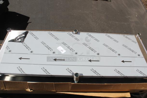 Large reflective panel with protective Novacel film, mounted on metal legs, labeled "105" for auction. Condition appears new.