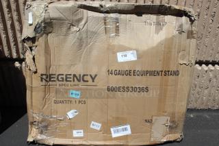 Damaged cardboard box containing Regency Spec Line 14-gauge equipment stand, model 600ESS3036S, with visible shipping labels.
