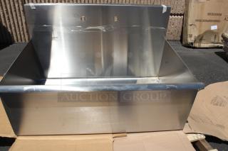 Stainless steel wall-mounted utility sink, new. Features a backsplash and mounting holes. Slight packaging marks visible.