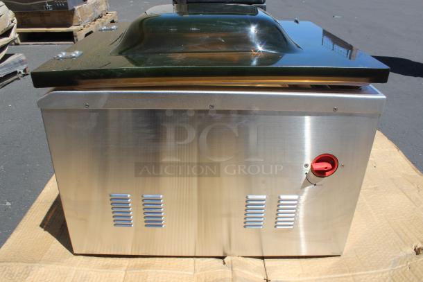 Stainless steel commercial vacuum sealer with a transparent lid, red power switch, and ventilation grates. Good condition.