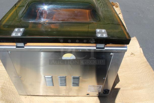 Stainless steel Vac-Packit vacuum sealer with transparent lid, visible label indicating model and specifications, appears in good condition.