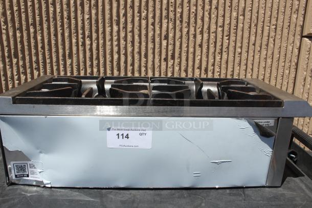 Commercial stainless steel countertop gas burner, four burners, visible dents, auction tag 114, QR code label included.