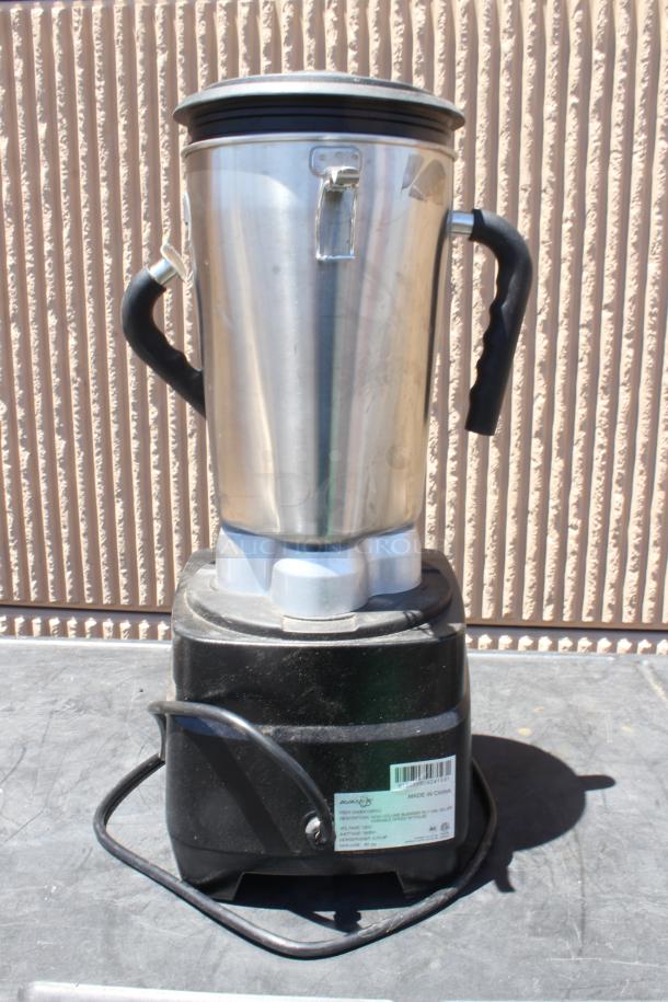 Commercial-grade metal blender with sturdy handles, black base, and visible manufacturer label. Good condition.