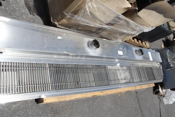Stainless steel air curtain with dual exhaust ports and protective grille. Includes visible identification labels. Appears in good condition.