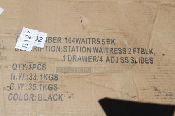 Cardboard box with labels reading: "Station Waitress 2 FT BLK, 1 Drawer/4 Adjustable SS Slides, Color: Black." Scuff marks visible.