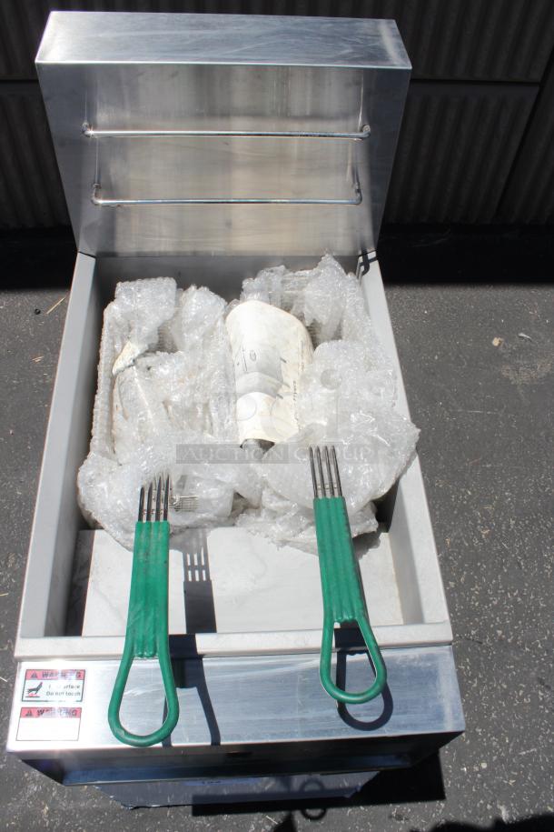 Industrial machine with two green-handled tools, packaged in bubble wrap. Warning labels with safety instructions visible.