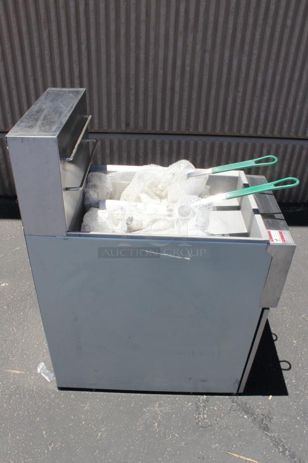 Commercial stainless steel deep fryer with double basket, green handles, bubble wrap interior, and label on front. Good condition.