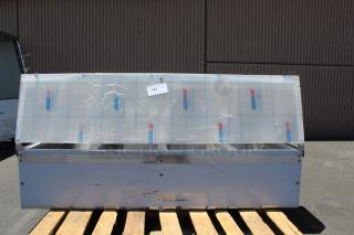 Large metal storage unit with protective film, mounted on a wooden pallet. Tag marked "123." Signs of wear and scratches.