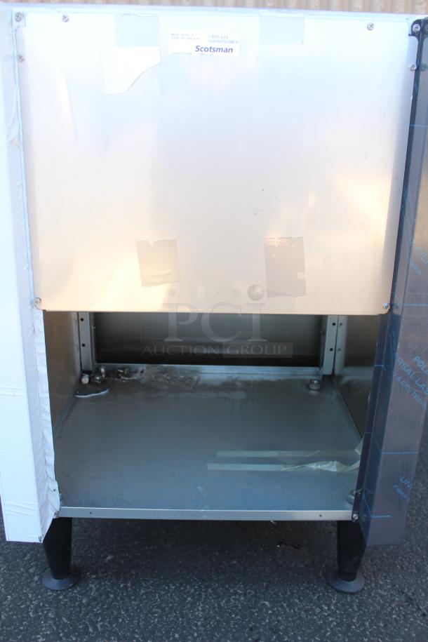 Scotsman commercial ice machine with stainless steel exterior, open interior, model name "N0922A-32", on adjustable legs.