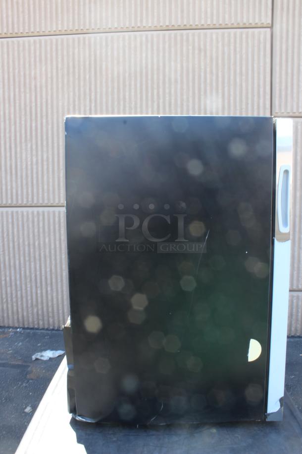 Black mini fridge with side handle, noticeable scratches, minor dents, suitable for small spaces or dorm use.